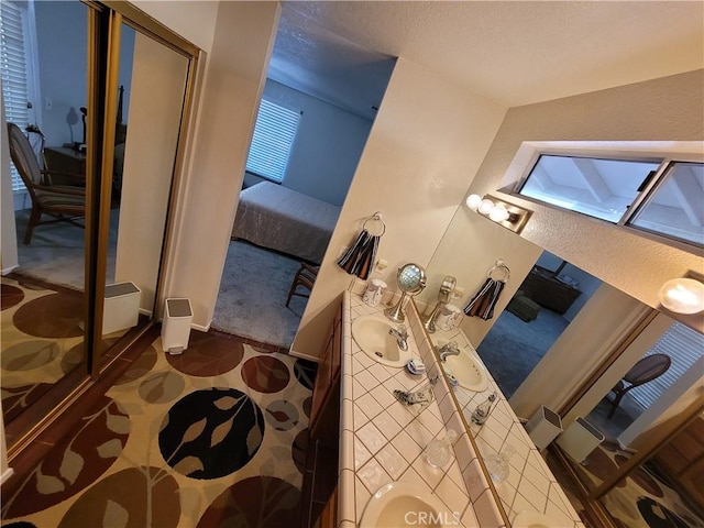 bathroom with sink and lofted ceiling