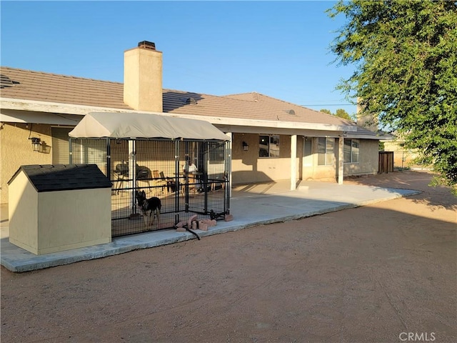 back of property featuring an outdoor structure