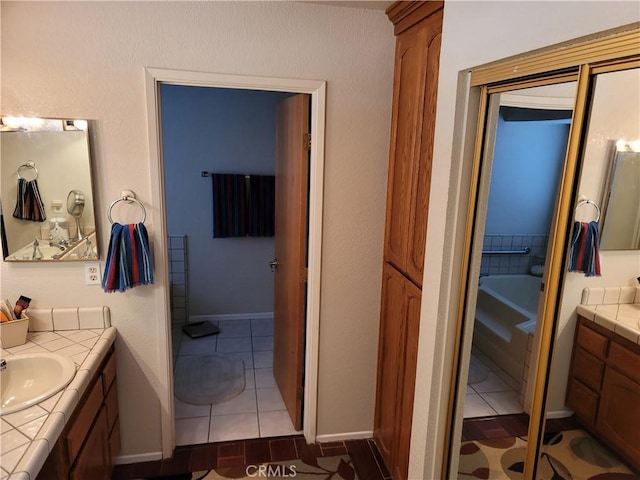 bathroom with tile patterned flooring, vanity, and a tub to relax in