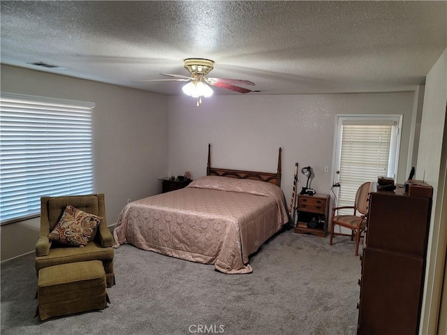 carpeted bedroom featuring a textured ceiling and ceiling fan