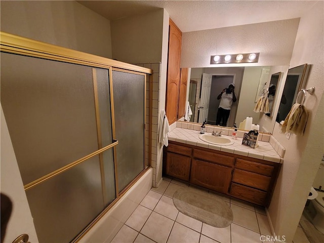 bathroom with tile patterned floors, shower / bath combination with glass door, and vanity