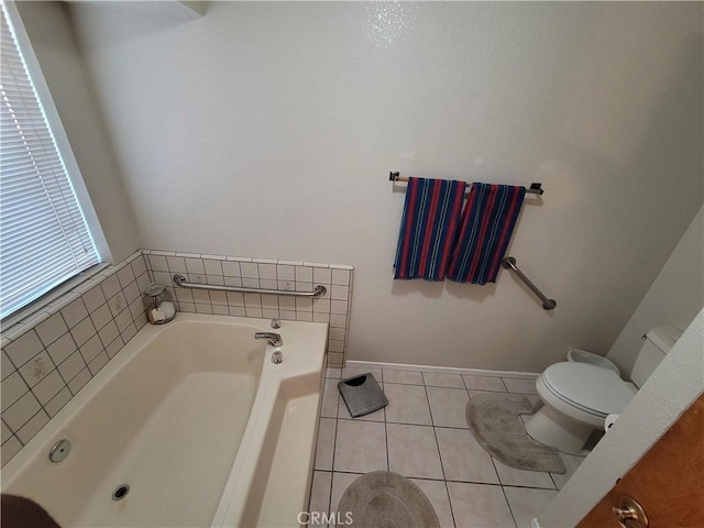 bathroom featuring tile patterned floors, toilet, and a tub