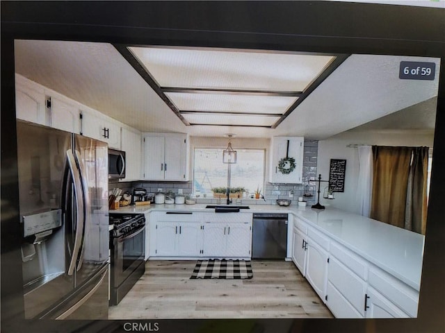 kitchen with white cabinets, sink, appliances with stainless steel finishes, and tasteful backsplash