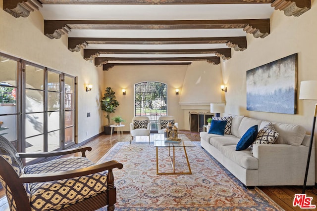 living room with a fireplace, beamed ceiling, and hardwood / wood-style floors