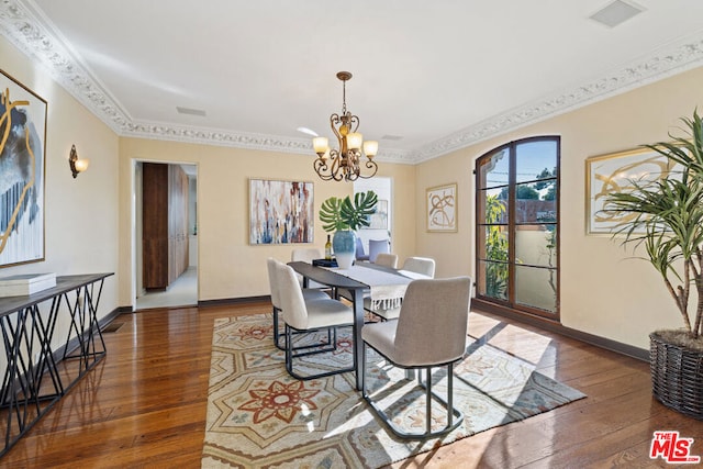 dining room featuring dark hardwood / wood-style flooring, crown molding, and a chandelier