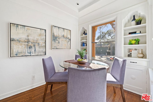 dining area with dark hardwood / wood-style floors and built in shelves