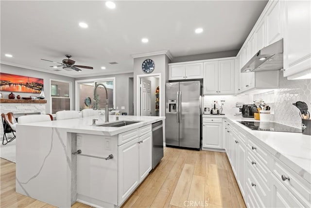 kitchen featuring white cabinets, stainless steel appliances, a kitchen island with sink, and sink