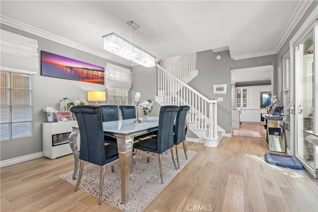 dining area featuring a chandelier, crown molding, and light hardwood / wood-style flooring