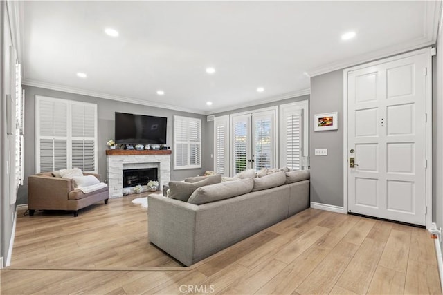 living room with a fireplace, light hardwood / wood-style floors, and ornamental molding