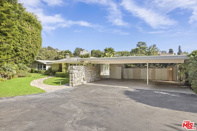 single story home with a front yard and a carport