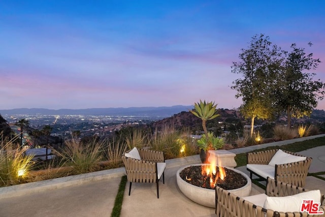 patio terrace at dusk with a mountain view and a fire pit