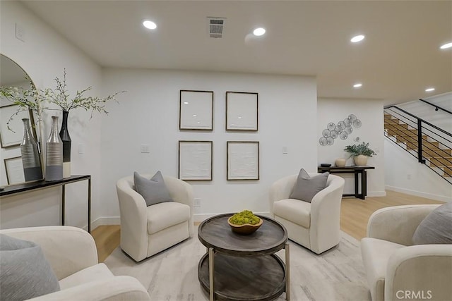 living area with light wood-type flooring, stairs, visible vents, and recessed lighting