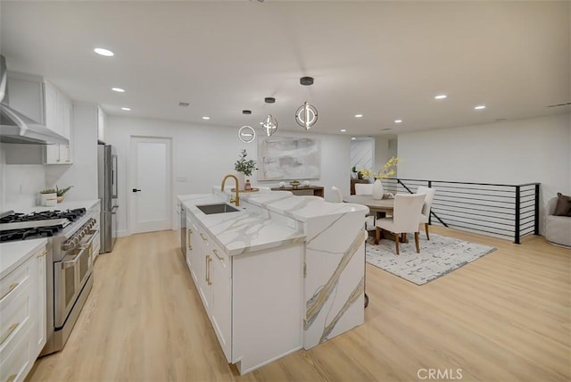 kitchen featuring appliances with stainless steel finishes, sink, white cabinetry, and a center island with sink