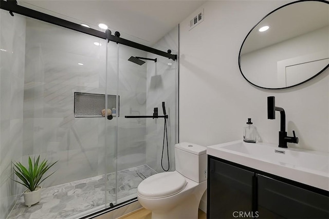 bathroom featuring an enclosed shower, vanity, and toilet