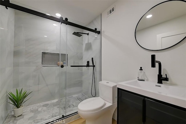 full bathroom featuring toilet, vanity, a shower stall, and visible vents