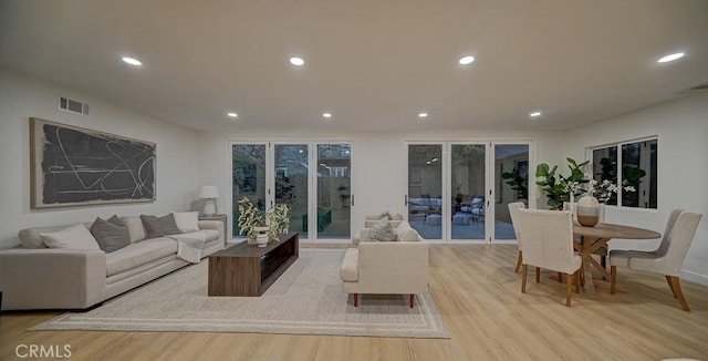 living room featuring light wood-style floors, recessed lighting, and visible vents