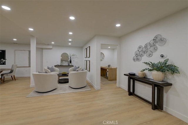 living area with baseboards, light wood-style flooring, and recessed lighting