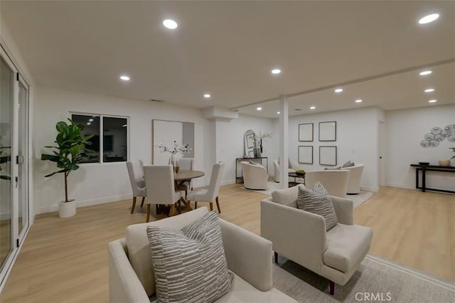 living room featuring light wood finished floors, baseboards, and recessed lighting