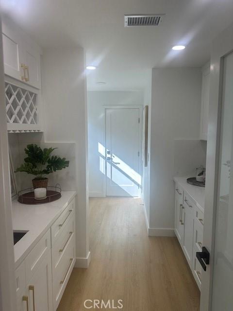 kitchen featuring light wood-type flooring and white cabinetry