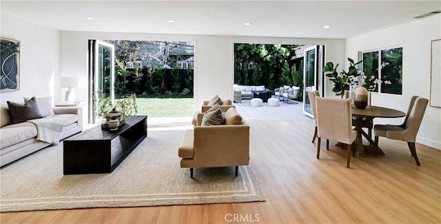 living room featuring light wood-style floors, recessed lighting, visible vents, and plenty of natural light