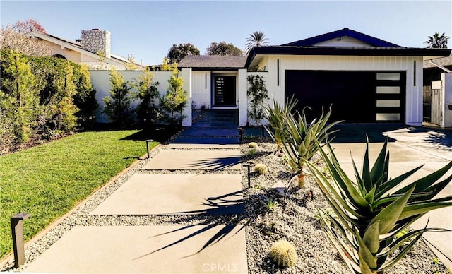 view of front of house featuring a garage and a front lawn