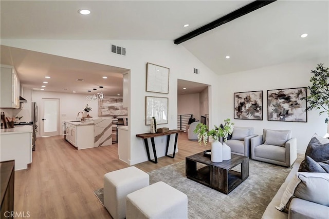 living area featuring light wood-style flooring, visible vents, beamed ceiling, and recessed lighting