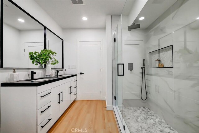 bathroom with an enclosed shower, vanity, and hardwood / wood-style floors