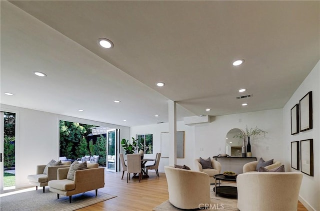 living room featuring recessed lighting, visible vents, and light wood-style flooring