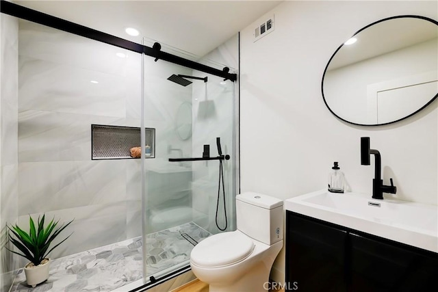 full bathroom featuring visible vents, a shower stall, toilet, and vanity