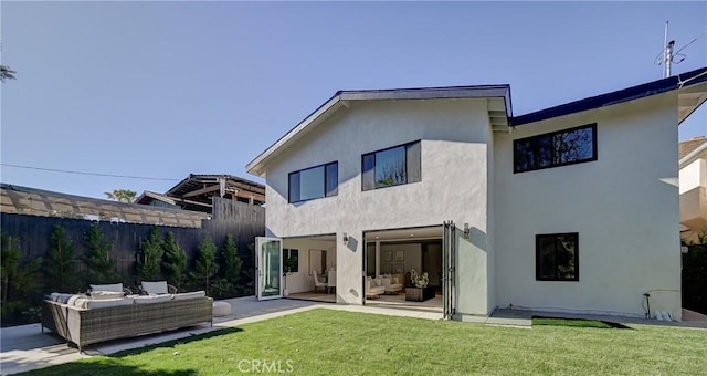 back of property featuring a patio, fence, a yard, outdoor lounge area, and stucco siding