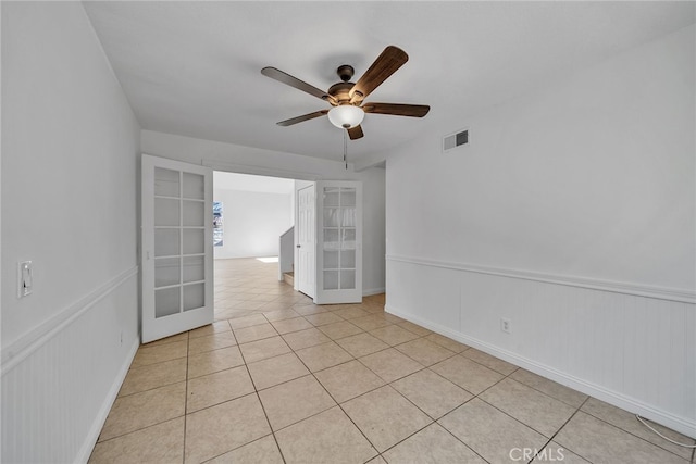 unfurnished room featuring ceiling fan, light tile patterned floors, and french doors