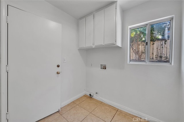 laundry area with light tile patterned floors, cabinets, and washer hookup