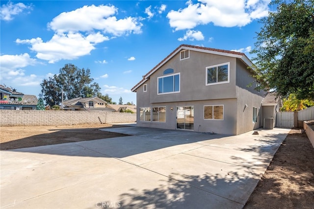 back of property with cooling unit and a patio area