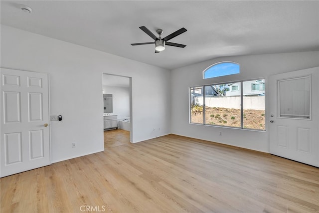 unfurnished bedroom featuring connected bathroom, ceiling fan, light hardwood / wood-style flooring, and lofted ceiling