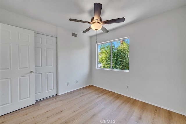 unfurnished bedroom with a closet, light hardwood / wood-style floors, and ceiling fan