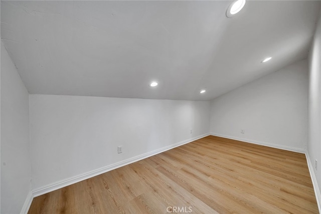 additional living space featuring light hardwood / wood-style floors and lofted ceiling