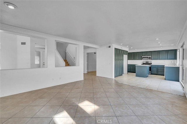 unfurnished living room with sink, light tile patterned flooring, and ornamental molding