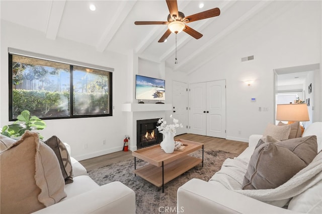 living room featuring beam ceiling, ceiling fan, hardwood / wood-style floors, and high vaulted ceiling