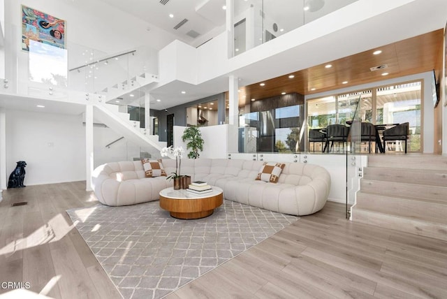 living room with a high ceiling and light wood-type flooring