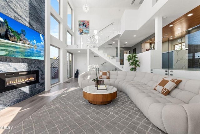 living room featuring hardwood / wood-style floors, a fireplace, and a high ceiling