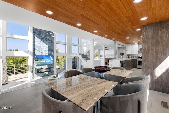 dining space featuring wooden ceiling and a fireplace