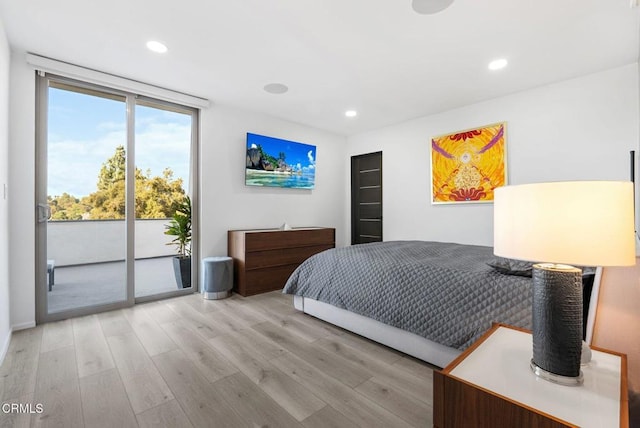 bedroom featuring access to exterior, light hardwood / wood-style flooring, and expansive windows