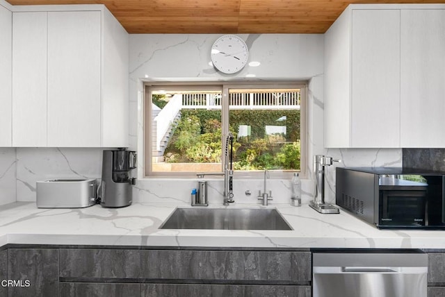 kitchen featuring sink, light stone counters, white cabinetry, wooden ceiling, and stainless steel dishwasher