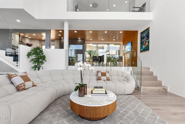 living room with a towering ceiling and light wood-type flooring