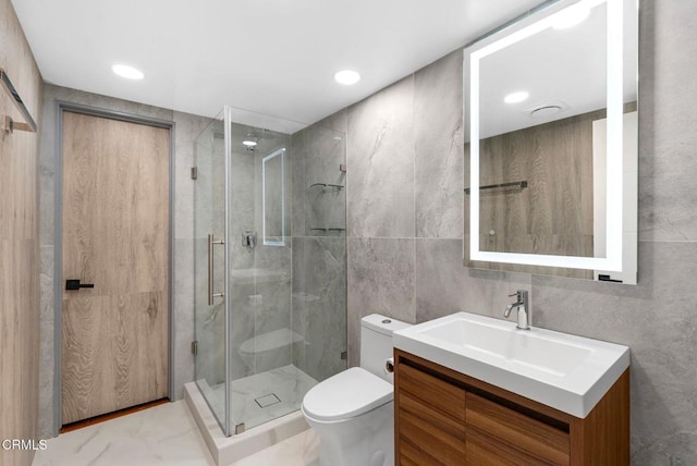 bathroom with walk in shower, vanity, toilet, and tile walls