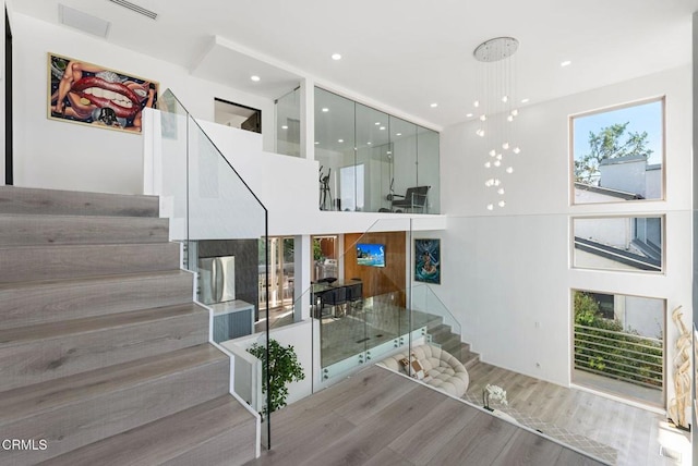 staircase with a towering ceiling and hardwood / wood-style floors