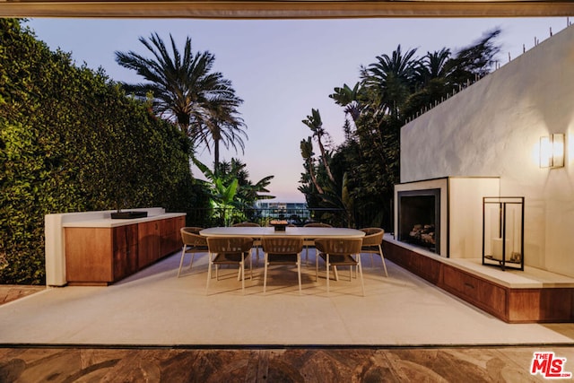 patio terrace at dusk with exterior fireplace