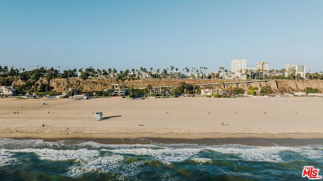 drone / aerial view with a water view and a beach view