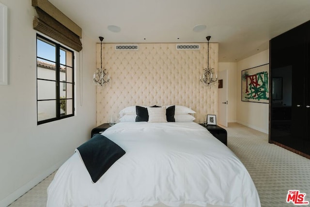 carpeted bedroom with an inviting chandelier