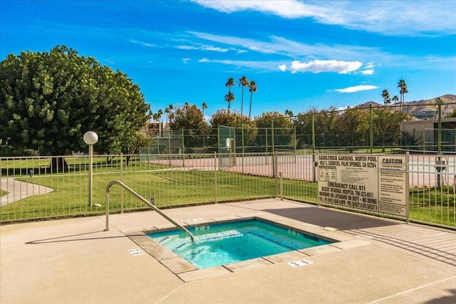 view of swimming pool featuring a lawn and a community hot tub